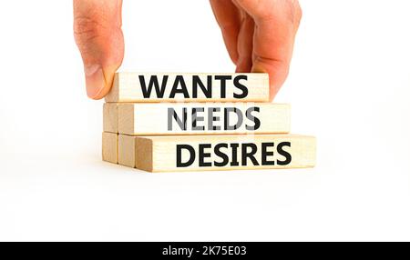 Wants needs and desires symbol. Concept words Wants Needs Desires on wooden blocks. Businessman hand. Beautiful white background. Business, psychologi Stock Photo