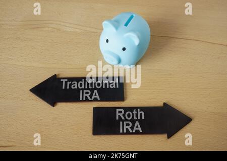 Blue piggy bank and arrows Traditional and Roth IRA. Stock Photo