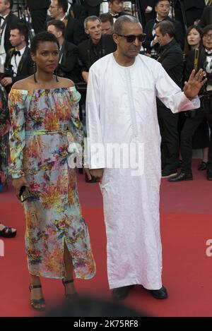 Mauritanian director Abderrahmane Sissako (R) and his wife Senegalese screenwriter Kessen Tall arrive on May 19, 2018 for the closing ceremony and the screening of the film 'The Man Who Killed Don Quixote' at the 71st edition of the Cannes Film Festival in Cannes, southern France. Stock Photo