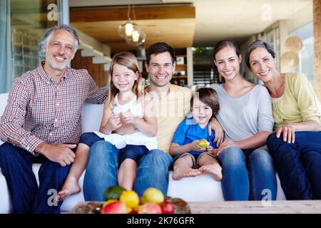 Theyre happiest when theyre all together. A portrait of a happy multi-generational family gathered at home in their living room. Stock Photo