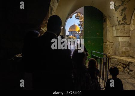 An Ultra Orthodox Jewish family loo at Dome of the Rock as they stand outside Bab al-Aa'tam or Gate of Darkness, known by a variety of names such as Gate of al-Dawadariya, Bab al-Malik Faisal or King Faisal Gate one of the three gates located on the north side of the Temple Mount leading to al-Aqsa Mosque compound in the old city of Jerusalem in Israel Stock Photo