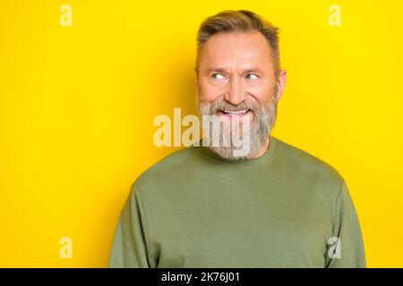 Photo of dreamy handsome man pensioner dressed green pullover looking empty space isolated yellow color background Stock Photo