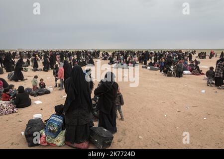 The Kurdish YPG of the coalition (Syrian Democratic Forces AKA SDF) are taking thousands of women and children of Daesh jihadists (ISIS) out of Baghouz, the last jihadist stronghold in Syria, in trucks to drop them at Al Hol camp a few hours away. Stock Photo