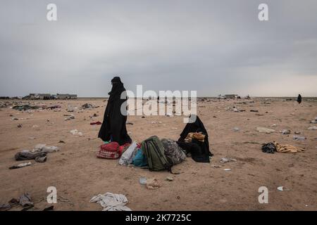 The Kurdish YPG of the coalition (Syrian Democratic Forces AKA SDF) are taking thousands of women and children of Daesh jihadists (ISIS) out of Baghouz, the last jihadist stronghold in Syria, in trucks to drop them at Al Hol camp a few hours away. Stock Photo