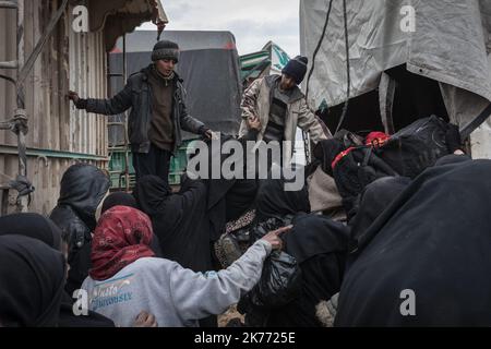 The Kurdish YPG of the coalition (Syrian Democratic Forces AKA SDF) are taking thousands of women and children of Daesh jihadists (ISIS) out of Baghouz, the last jihadist stronghold in Syria, in trucks to drop them at Al Hol camp a few hours away. Stock Photo