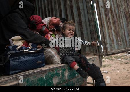 The Kurdish YPG of the coalition (Syrian Democratic Forces AKA SDF) are taking thousands of women and children of Daesh jihadists (ISIS) out of Baghouz, the last jihadist stronghold in Syria, in trucks to drop them at Al Hol camp a few hours away. Stock Photo