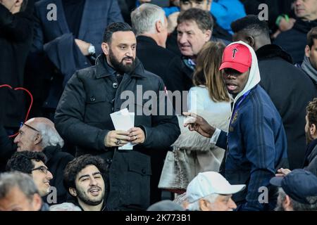 Cyril Hanouna and Paul Pogba during Round of 16, second leg of UEFA Champions League match between Paris Saint Germain and Manchester United FC at the Parc des Princes, in Paris on March 6th, 2019. Stock Photo
