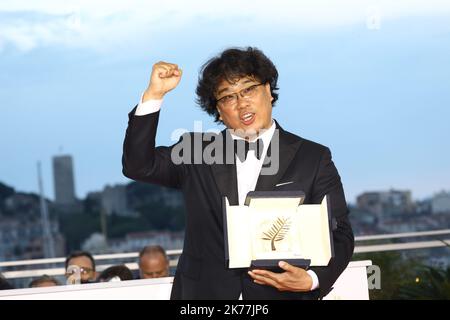 Director Bong Joon-Ho, winner of the Palme d'Or award for his film Parasite poses at the winner photocall during the 72nd annual Cannes Film Festival on May 25, 2019 in Cannes, France. Stock Photo