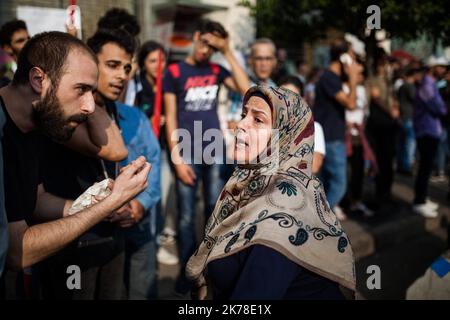 Lebanon / Beirut  -  Pro-Revolution protesters are trying a sit in to prevent the pro hezbollah from occupying the space. they will be repulsed by the police who will make a cordon between the two groups. In the vicinity of the seat of government the atmosphere remains calm. Lebanese revolution week 1. the situation became tense in the afternoon in front of the government headquarters, where hezbollah supporters (without party flags) came to mingle with the crowd, to listen to Hassan Nasrallah's speech. Some clashes took place with the police who were blocking between protesters and counter-pr Stock Photo