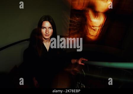 Creative woman portrait on dark background with blurred lights Stock Photo