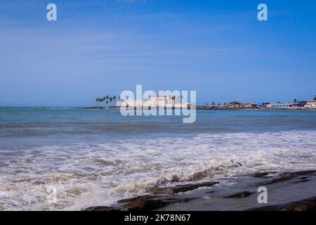 Far View to the Cape Coast Slave Castle from the  Atlantic Ocean Coastline in Ghana, West Africa Stock Photo