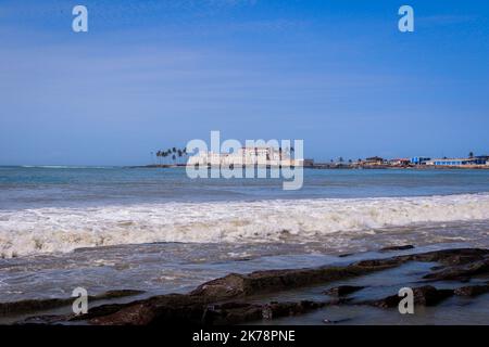 Far View to the Cape Coast Slave Castle from the  Atlantic Ocean Coastline in Ghana, West Africa Stock Photo