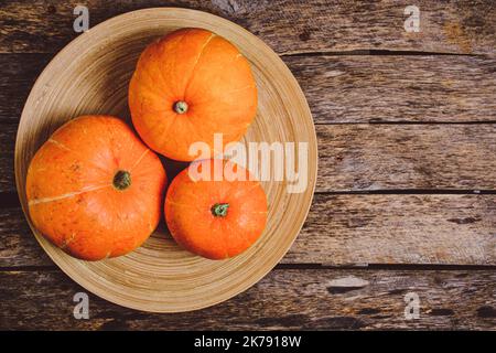 Pumpkins in wooden plate on wooden background Stock Photo