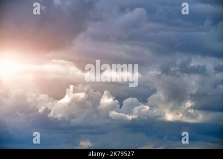 Breaking sunlight through gap of storm clouds Stock Photo