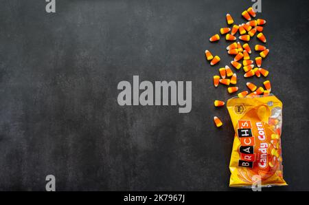 Moscow, Russia, September 2021: Candy corn candies spilled out of pack. Traditional sweets on Halloween. Treat or trick. Copy space. Stock Photo