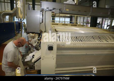 Employees processing linen at the laundry at the Emile Muller hospital in Mulhouse Stock Photo