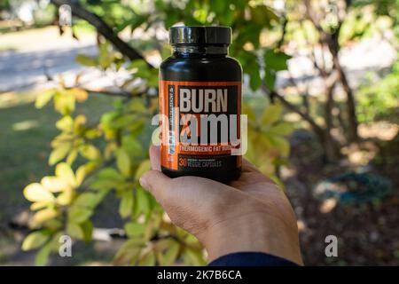 New Hope, Minnesota-  October 6, 2022: Hand holds a bottle of Burn XT thermogenic fat burner weight loss pills Stock Photo