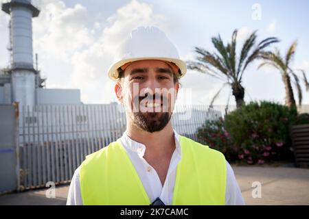 Portrait of handsome caucasian man wearing protective clothes outdoors at thermoelectric industry. Stock Photo