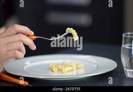 ©PHOTOPQR/L'ALSACE/Vanessa MEYER ; ; 02/06/2021 ; La main d'une jeune fille devant une assiette presque vide et un verre d'eau tient une fourchette avec une pâte. Les troubles du comportement alimentaire ont augmenté pendant la crise sanitaire. - anorexia Stock Photo