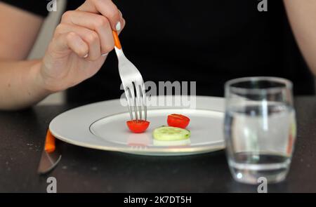 ©PHOTOPQR/L'ALSACE/Vanessa MEYER ; ; 02/06/2021 ; Une assiette presque vide avec une tomate cerise et une rondelle de concombre. Une jeune femme anorexique refuse de s'alimenter. Les troubles du comportement alimentaire ont augmenté pendant la crise sanitaire. - anorexia Stock Photo