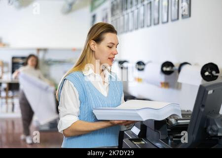 Technician working on plotter and cutter machine in printing shop Stock Photo