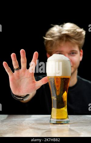 No alcohol. Young man refuses to beer. Young man stop drinking. alcohol addiction Stock Photo