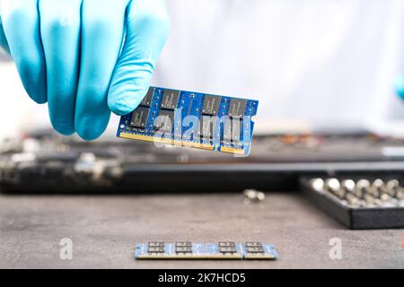 Hands of a technician repairing a broken laptop computer Stock Photo