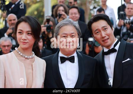 ©PHOTOPQR/NICE MATIN/Patrice Lapoirie ; Cannes ; 23/05/2022 ; From L) South Korean actor Park Hae-Il, South Korean director Park Chan-Wook and Chinese actress Tang Wei arrive for the screening of the film 'Decision to Leave (Heojil Kyolshim)' during the 75th edition of the Cannes Film Festival in Cannes, southern France, on May 23, 2022. - International Cannes film festival on may 23rd 2022  Stock Photo