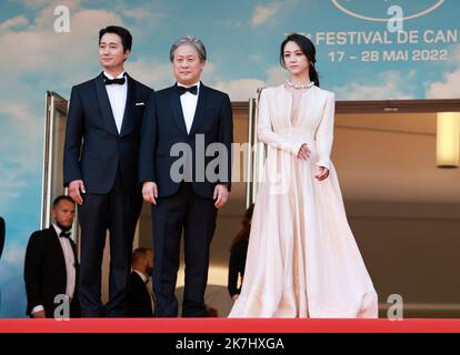 ©PHOTOPQR/NICE MATIN/Patrice Lapoirie ; Cannes ; 23/05/2022 ; From L) South Korean actor Park Hae-Il, South Korean director Park Chan-Wook and Chinese actress Tang Wei arrive for the screening of the film 'Decision to Leave (Heojil Kyolshim)' during the 75th edition of the Cannes Film Festival in Cannes, southern France, on May 23, 2022. - International Cannes film festival on may 23rd 2022  Stock Photo