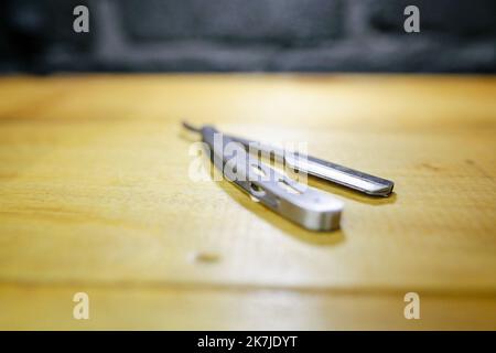 Open old dangerous razor on a wooden background. isolated, blade. Stock Photo