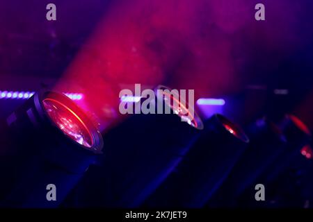 Stage moving head lights. Red light beams and smoke. Selective focus. Stock Photo
