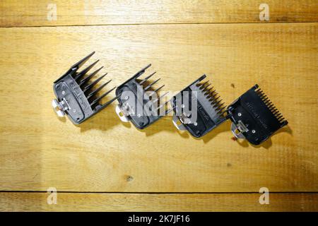 Various black Hair Clipper Comb Guide attachments for Electric Hair clippers on a white towel at a barbershop. Stock Photo