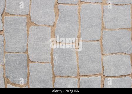 Texture of fragment of gray path made of masonry with sand in seams between paving stones. Top view Stock Photo
