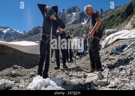 ©PHOTOPQR/LE DAUPHINE/Baptiste SAVIGNAC ; Chamonix-Mont-Blanc ; 04/07/2022 ; Pour observer l'évolution de la Mer de Glace, le glaciologue Luc Moreau perce un nouveau trou d'une profondeur de six mètres dans le glacier. Il y glisse ensuite un jalon en bambou, qu'il marque au feutre pour mesurer régulièrement l'épaisseur de glace fondue. Chamonix-Mont-Blanc; France 04/07/2022; To observe the evolution of the Mer de Glace, the glaciologist Luc Moreau drills a new hole six meters deep in the glacier. He then slides a bamboo stake into it, which he marks with a marker to regularly measure the thic Stock Photo