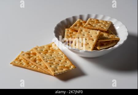 Crackers in a dish placed on a white background. Close-up. Stock Photo