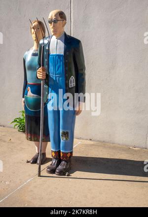 Grant Wood's American Gothic House, Eldon, Iowa; statues of man and woman with a pitchfork Stock Photo