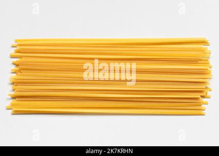 Durum fettuccine pasta on white background. Raw spaghetti or noodles Stock Photo