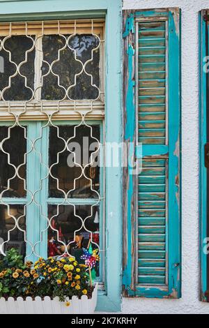 Wooden windows and shutters painted blue in house at sunset Stock Photo