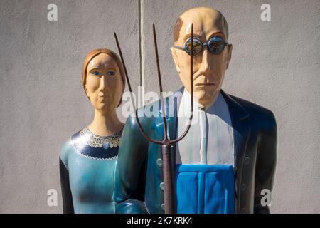 Grant Wood's American Gothic House, Eldon, Iowa; statues of man and woman with a pitchfork Stock Photo