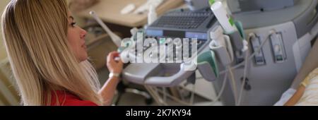 Gynecologist performs ultrasound scan on young woman with problems of female reproductive system Stock Photo