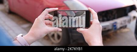 Woman holding smartphone and taking picture of car accident Stock Photo