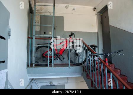 Ukraine Dnipro 23.07.2021 - Two red bicycles stand on the stairs to the entrance of a residential building on the floor they brought apartments, a bic Stock Photo