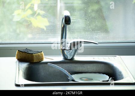 dirty dishes in the sink on the table in the kitchen under the tap, dirty dishes in mocha in the kitchen at home Stock Photo