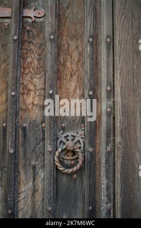 very old weathered rusted door ring handle on ancient wooden door Stock Photo