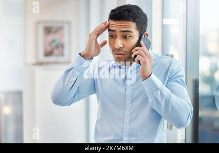 You have horrible timing. a handsome young businessman making a phone call using his smartphone. Stock Photo