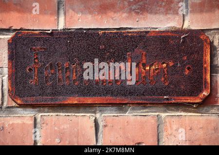 Historic rusty sign with the German word Feuermelder - fire alarm. Stock Photo