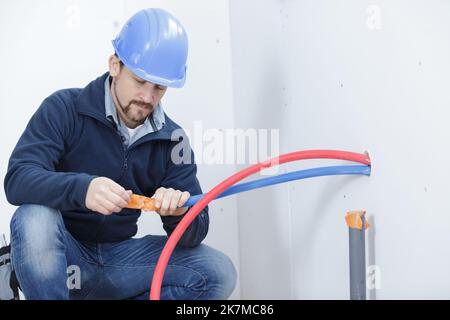 man in hardhat using cables Stock Photo