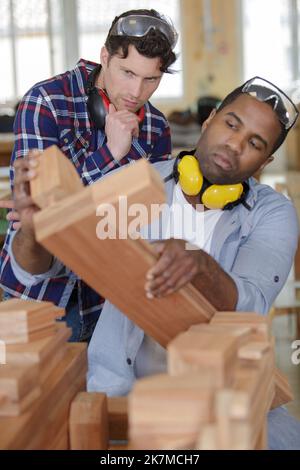young carpenter with students in woodworking workshop Stock Photo