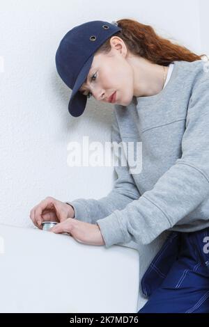 female plumber inspecting the toilet tank Stock Photo