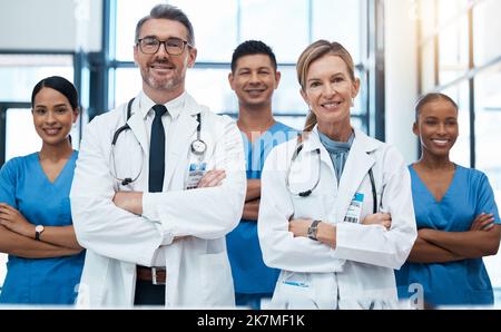 Doctors, nurses and team portrait in hospital, clinic or medical office. Teamwork, diversity and healthcare professionals standing together with arms Stock Photo